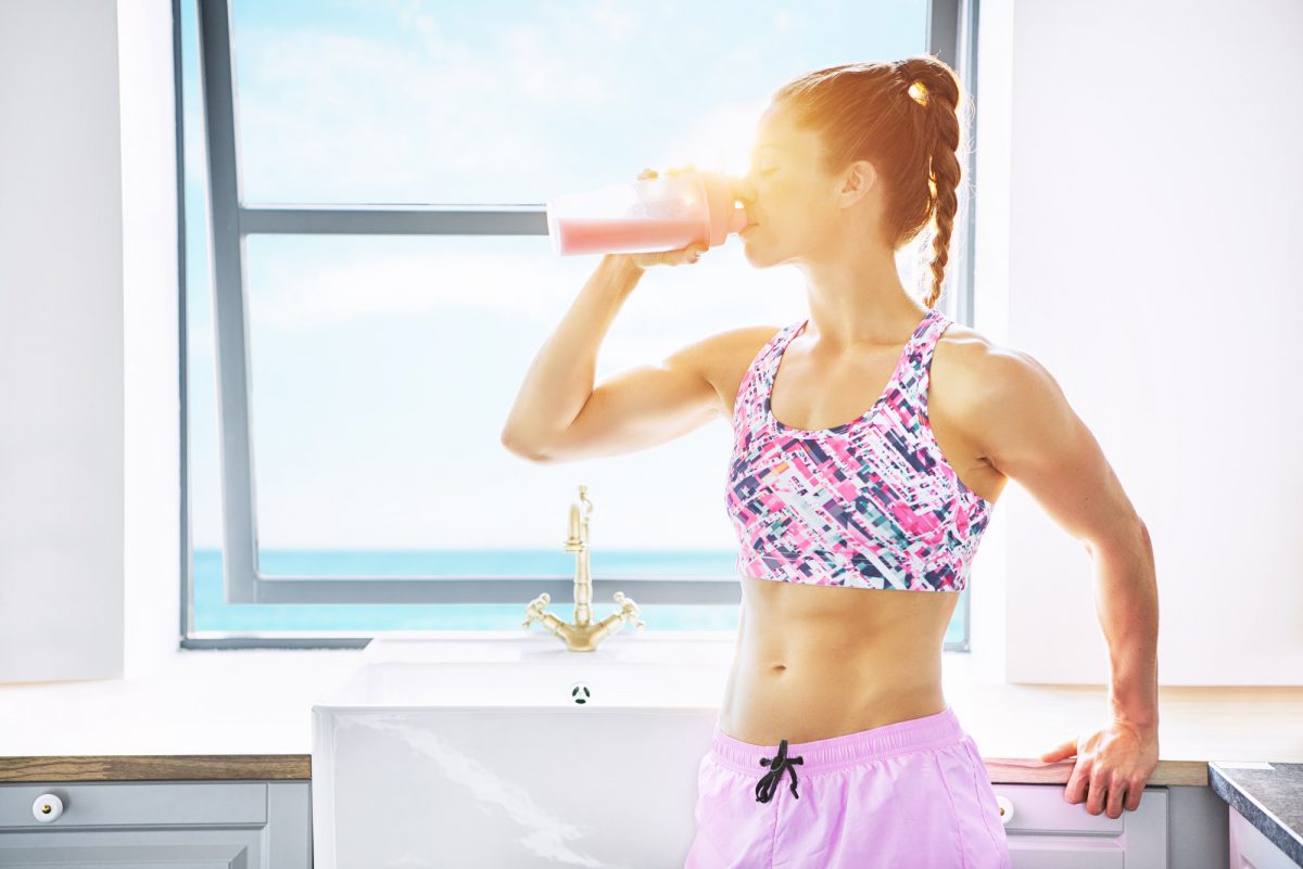 Fit healthy woman drinking fresh fruit juice